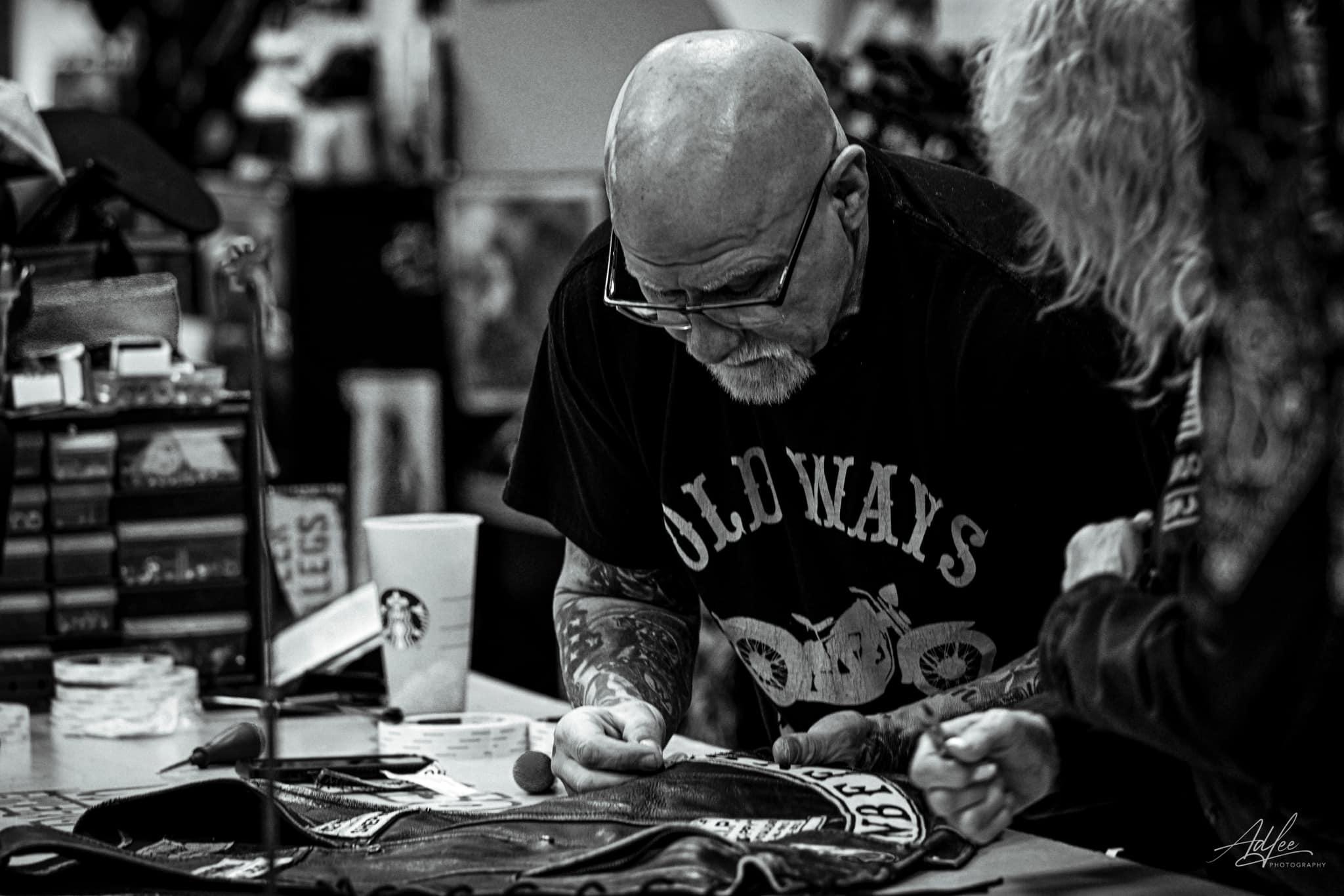 Old industrial sewing machine stitching leather for riders